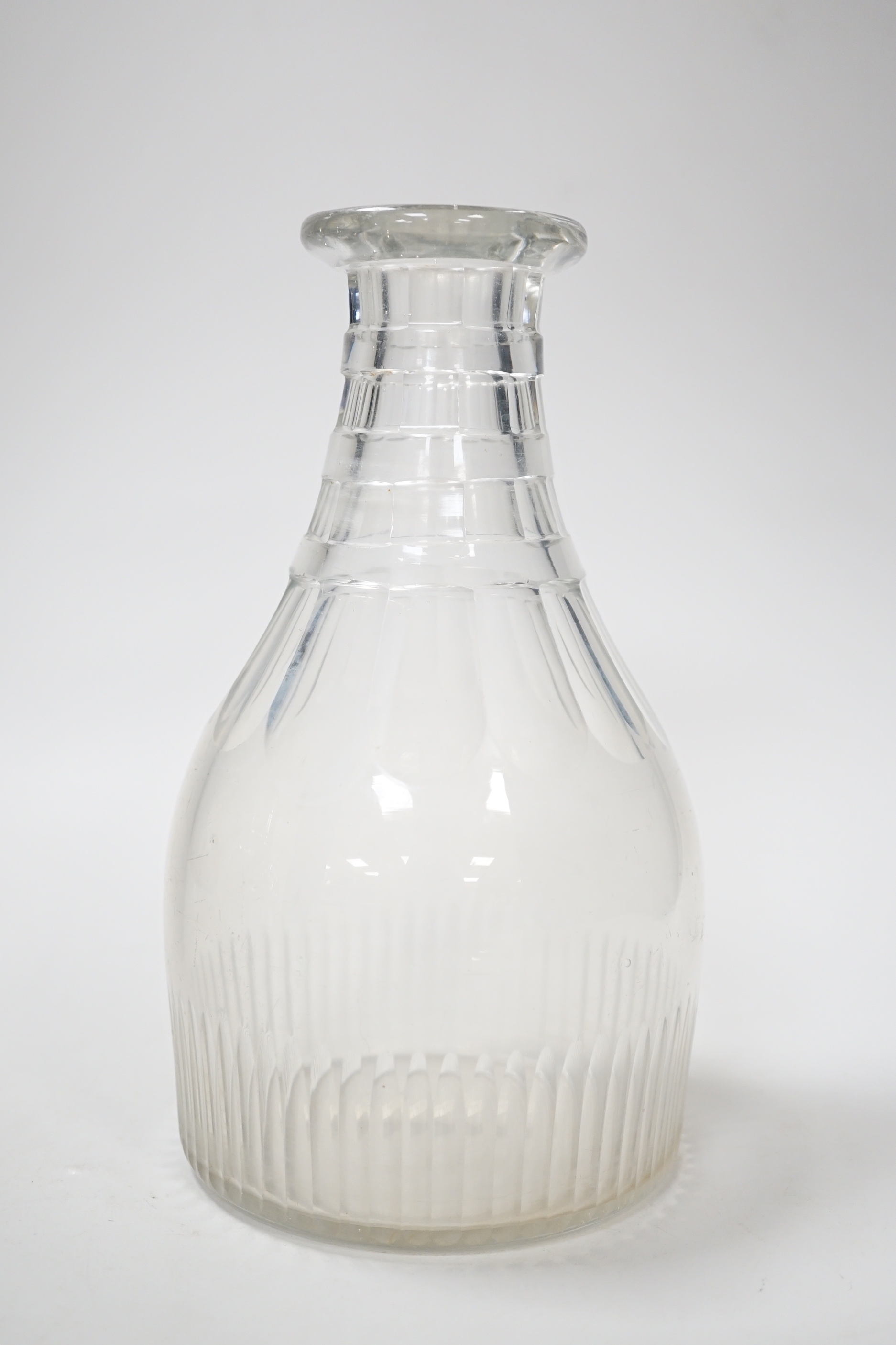 A rare English lead crystal Georgian carafe, c.1810-30, three rows of square cut facets replace earlier rings around neck followed by rounded facets and basal flutes, the base with ground and polished pontil, 22cm high